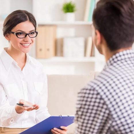Eine Frau in einem weißen Hemd hält ein Klemmbrett 